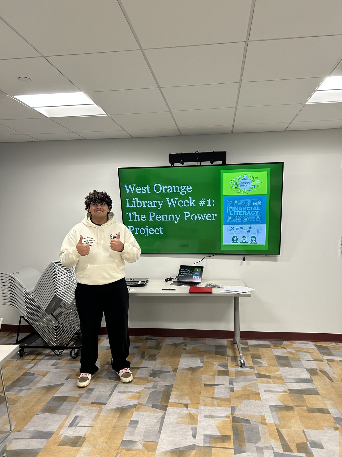 Girick presenting in front of a smart board at the West Orange Library